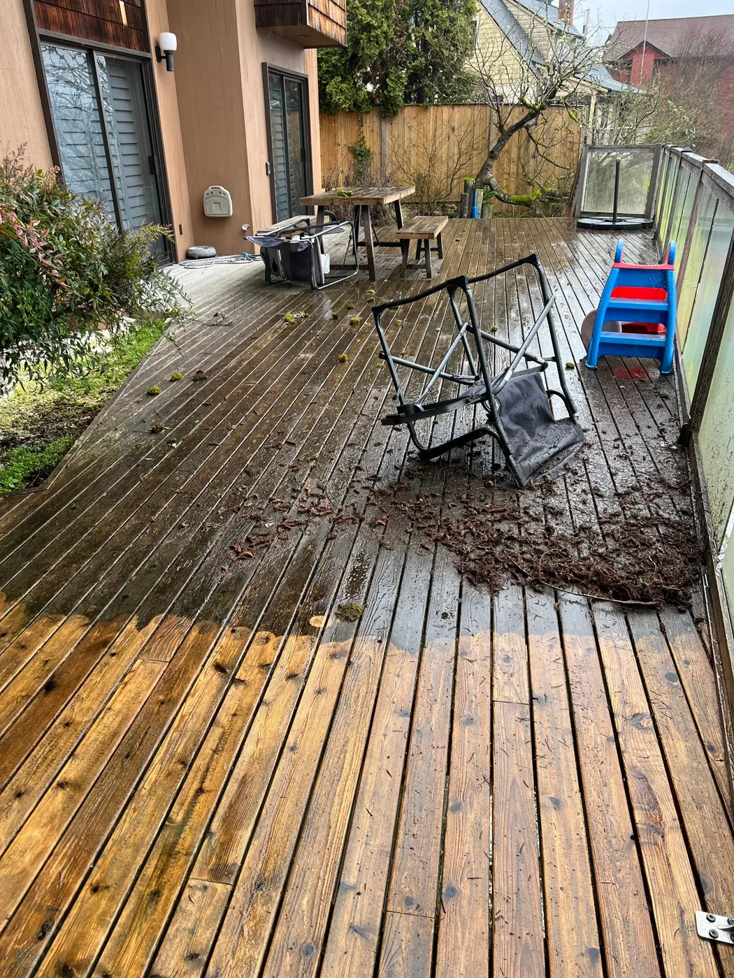 Cedar deck half pressure washed, showing the dirty and clean boards side by side